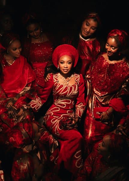 Bride surrounded by friends in red at a traditional wedding