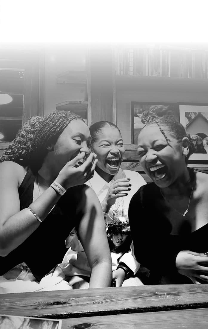 Friends laughing on a wooden bench
