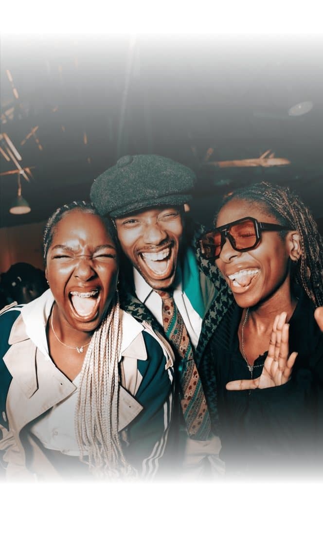 Three friends laughing at a party