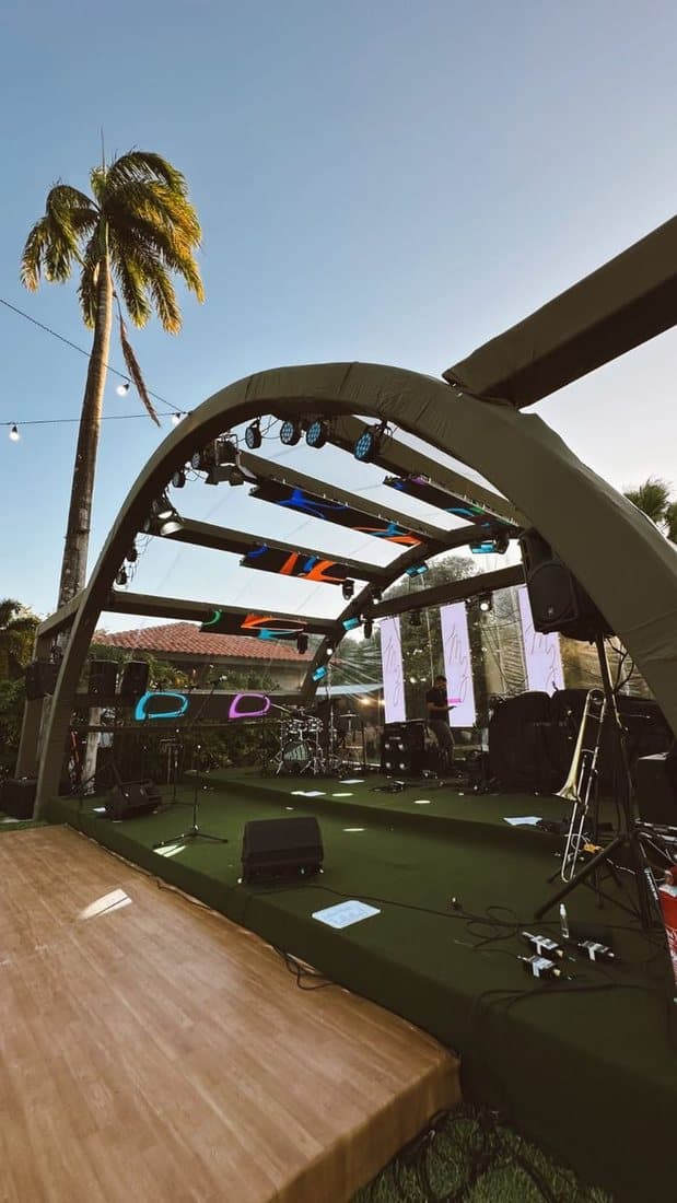Outdoor stage set up beneath palm trees