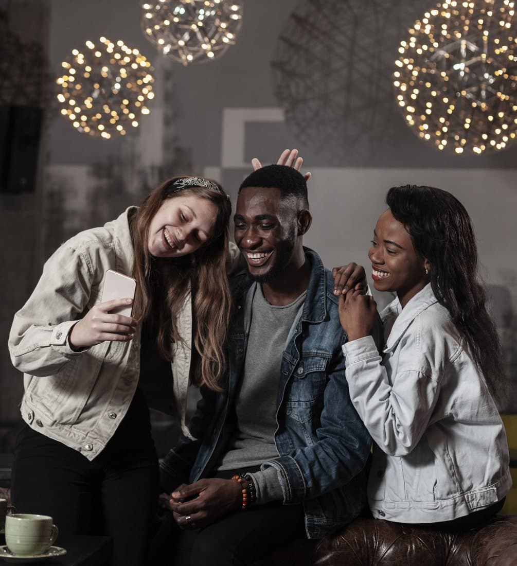 Friends laughing together under string lights